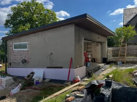 Garáž v hrubé stavbě, šedé zdivo před fasádou