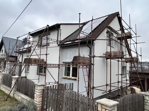 Tentýž patrový dům na lešení s novou bílou fasádou